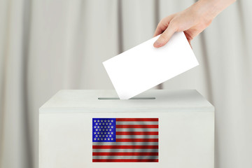 USA Vote concept. Voter hand holding ballot paper for election vote on polling station