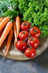 fresh vegetables  carrots and tomato on wooden background
