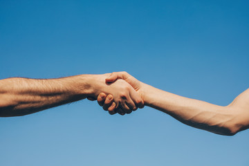 two hands shaking hands. Love concept. Sky background. 