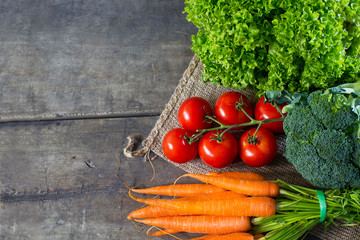 Wooden background with market fresh vegetables, tomatoes, carrot, lettuce and broccoli on a wooden table with copy space 