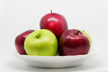 A bunch of apples on a plate with isolated white background