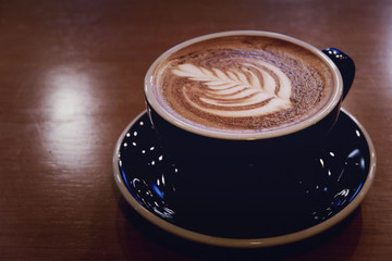 A cup of coffee with latte art served on the table