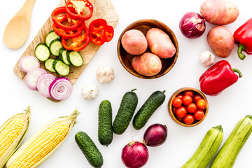 Fresh vegetables still life. Potato, cucumber, beet carrot, greenery on white background top-down