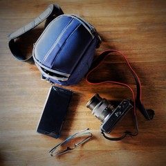 Camera & it's Bag, Phone and Glasses before Going for Picture Hunting. Top View.