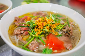 Vietnanese beef pho with sriracha sauce shot from overhead at Hoi An old town. Hoi An is a popular tourist destination of Asia. ( Pho Lien )
