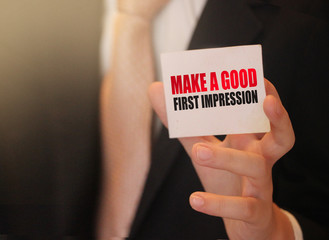 Make a good first impression on a card Businessman holding. Motivation and personal coaching concept