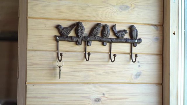 the hand of a married woman removes the key to the house from the hook