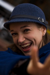 Stylish young lady on the street walks in spring in blue coat and cap.