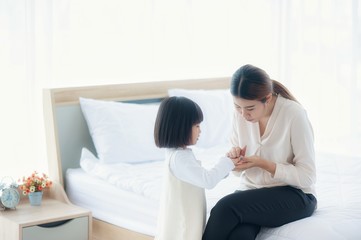 Obraz na płótnie Canvas Asian Mother is teaching daughter wash hands with alcohol gel. To kill corona virus in the bedroom