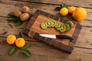 Fruit with knife on wooden cutting board