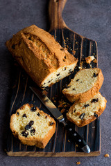 Long homemade cake with raisins. Dark background