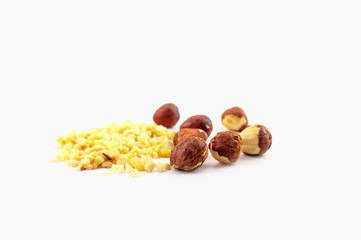A pile of chopped almonds and whole hazelnuts isolated on a white background.