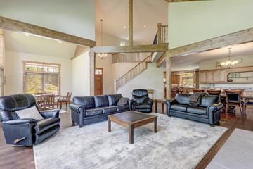 Very large rustic classic American home living room interior with vaulted tall ceilings, stone...