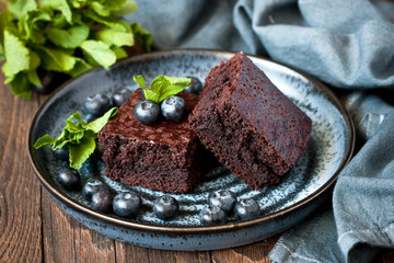 Chocolate brownie portion on dark plate, selective focus