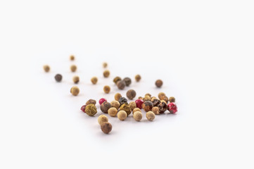 Red, green and black peppercorns or balls mixed isolated on a white background.