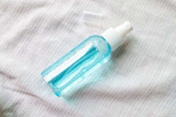 Naklejka premium Alcohol spray bottle on a white fabric background