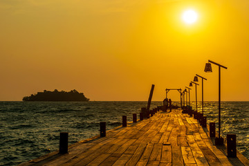 Fototapeta na wymiar A pier with the sunrise in the background from the White Beach, Koh Rong, Cambodia