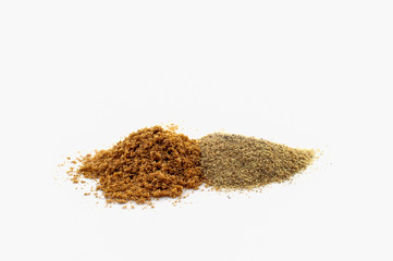 A pile of ground peppers of various types at different grindings isolated on a white background.