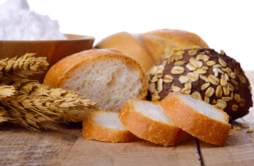 Assortment of baked bread on wooden table background