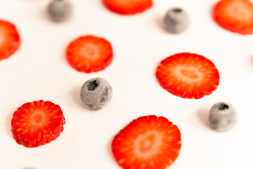 ripe, fresh, natural red cut strawberries and blueberries pattern, a healthy spring and summer fruit, on white background