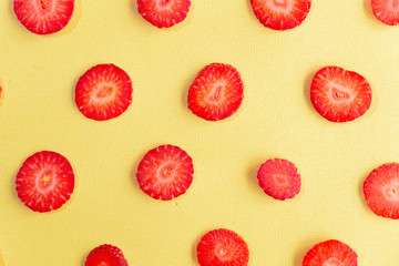 ripe, fresh, natural red cut strawberries pattern, a healthy spring and summer fruit, on yellow background