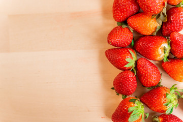 ripe, fresh, natural red whole strawberries, a healthy spring and summer fruit, on wooden table background