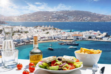 Konzept der griechischen Küche mit Bauernsalat und Olivenöl vor der atemberaubenden Aussicht auf...