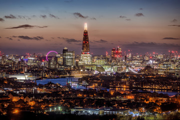 Die Skyline von London, Großbritannien, am Abend mit den beleuchteten Wolkenkratzern und...