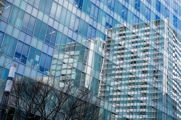 Osaka, Japan-January 18, 2019 : Closeup and crop city buildings and blue sky reflection on glass office building windows