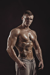 Obraz na płótnie Canvas Studio portrait of a shirtless athletic tattooed male.