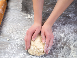 Woman hands kneading dough on the table