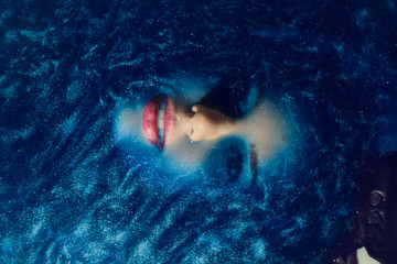 Fototapeta na wymiar Model in colorful blue water like space. Deep color and texture.