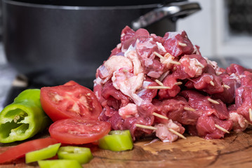 Beef stacked on sticks, on a wooden board