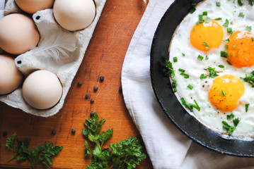 Breakfast with fried eggs, chicken eggs on the table.