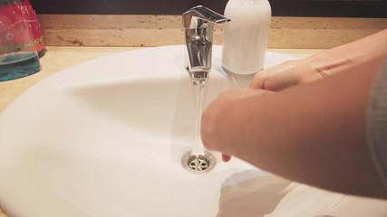 Woman washes hands in a sink with soap. Hands washing to prevention diffusion of virus and bacteria. Healthcare, cleaning, basic home hygiene rules