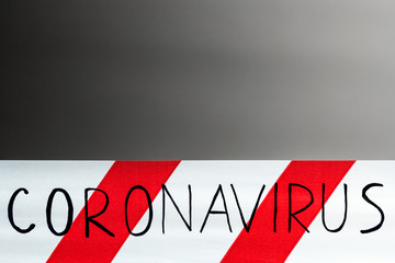 Label coronavirus. Red and white warning tape with the inscription coronavirus close up on black...