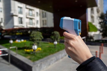 Woman hand holding infrared  thermometer