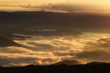 Sunset over the mountains. Cover with fog . Warm light 