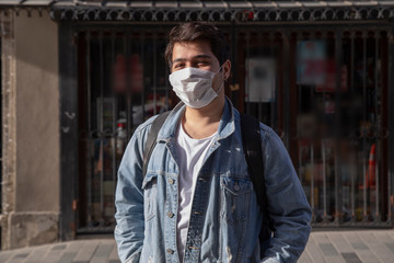 Fototapeta premium Young man is walking on the street with a protective mask
