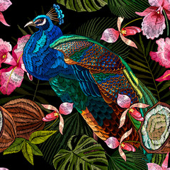 Colorful peacocks, orchid flowers, palm leaves and coconut. Embroidery tropical seamless pattern. Jungle forest and exotic birds. Fashionable template for design of clothes, textile