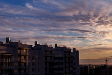 Urban industrial landscape in the evening at sunset. Beautiful blue sky, creative business buildings and residential buildings. Panoramic image from a height