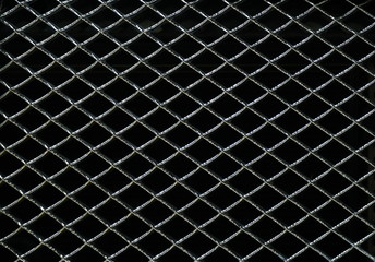 Steel grating with gloss on a black background. Seamless texture metal wire fence. Image for using...