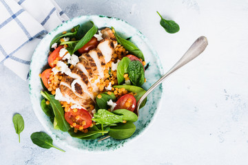 Salad with red lentils, spinach leaves, cherry tomatoes, chicken meat and mozzarella cheese with...