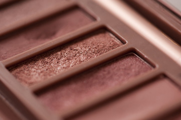 Eye shadow palette with rose gold glitter tones closeup. Beauty products. Selective focus.