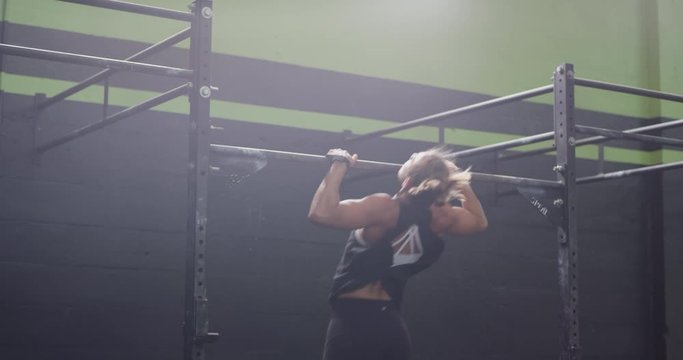 Two females doing pullups in gym