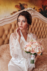 beautiful bride with blond hair in elegant lace robe having morning preparation in wedding day