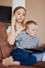 Busy mother holding her son and talking on the phone
