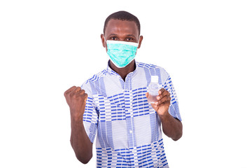 young man wearing medical mask holding bottle of antibacterial g