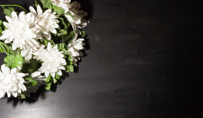 Funeral symbol. A bouquet of white flowers on the side, black background, free space for text.