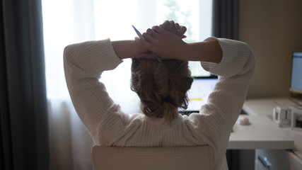 Take a break, a young woman in the workplace at the computer, stopped